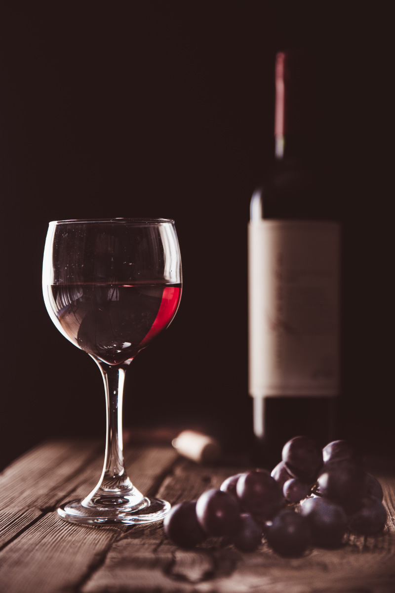 a bottle of wine and a glass sitting on top of a wooden table